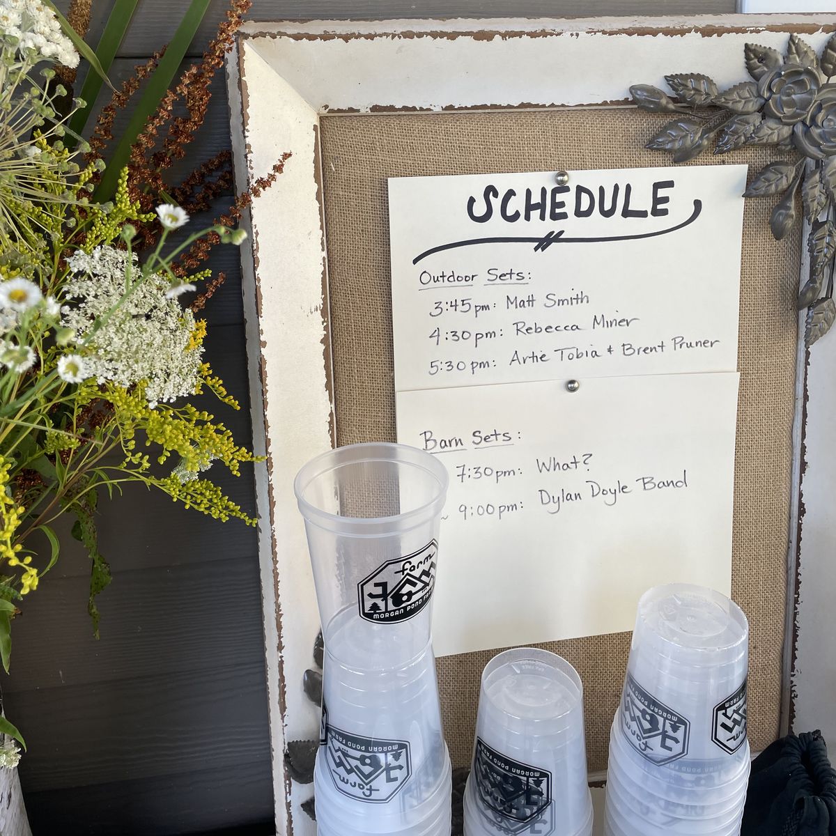 Farm Jam cups beside the event schedule board