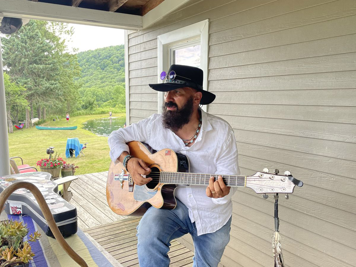 Artie Tobia playing guitar on the porch