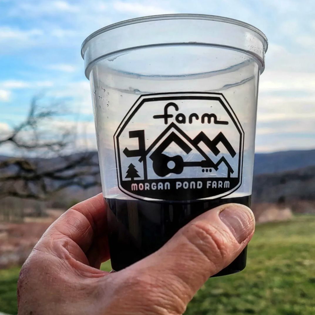 Farm Jam cup, held up against a mountain view