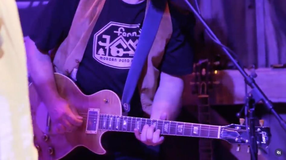Musician wearing a Farm Jam t-shirt on stage